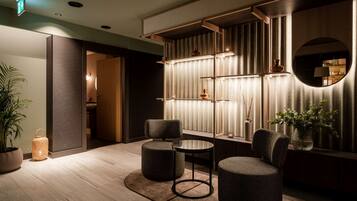 Een moderne lobby met een zithoek, een receptiebalie en een decoratieve wand met planken.