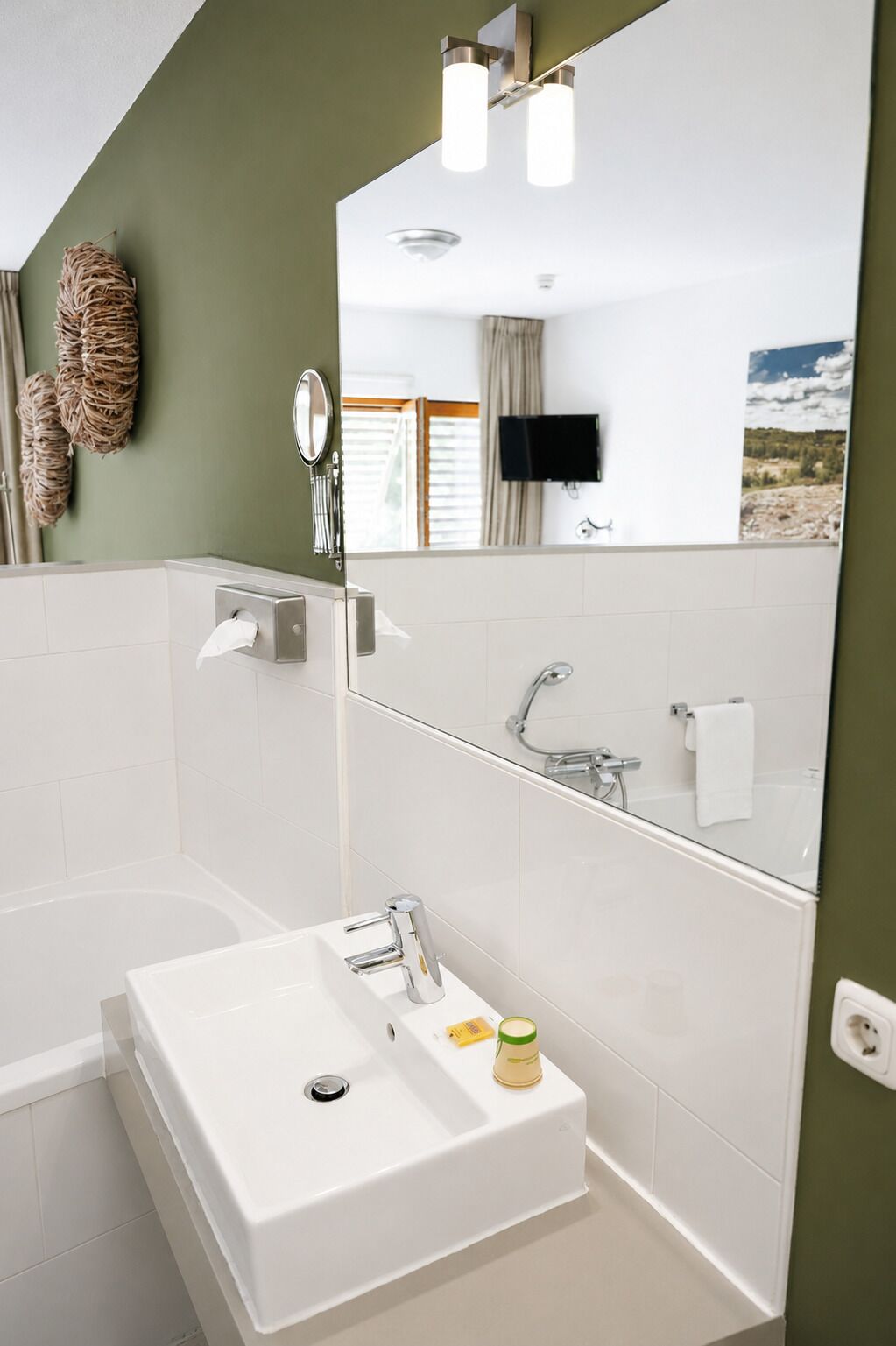 Une salle de bain moderne avec une baignoire blanche, un lavabo avec un miroir et une douche.