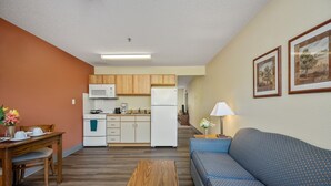 A compact living space with a kitchenette, a dining area, and a sofa.