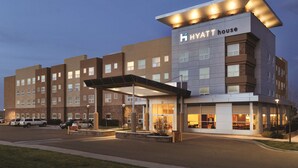 A multi-story hotel with a modern design, featuring a covered entrance and a visible restaurant area. - Hyatt House Denver Airport (Denver)