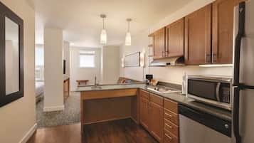 A modern kitchen with wooden cabinets, a built-in microwave, and a dishwasher.