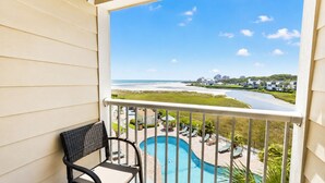 A balcony with a view of a swimming pool and beach. - Sands Beach Club (Myrtle Beach)