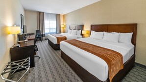 A hotel room with two beds, a desk, a chair, and a TV. - Comfort Inn (Dawson Creek)