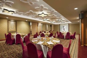 A conference room with round tables, red chairs, and a patterned carpet. - The Royal Surakarta Heritage - Handwritten Collection (Surakarta)