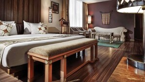 Una habitación de hotel con una cama grande, un banco, un escritorio y una silla.