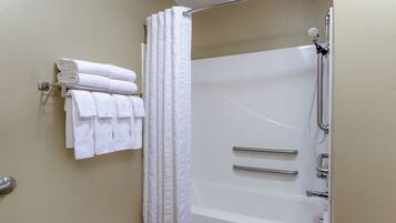 Une salle de bain équipée d’une baignoire, d’une douche et d’un porte-serviettes avec des serviettes pliées.