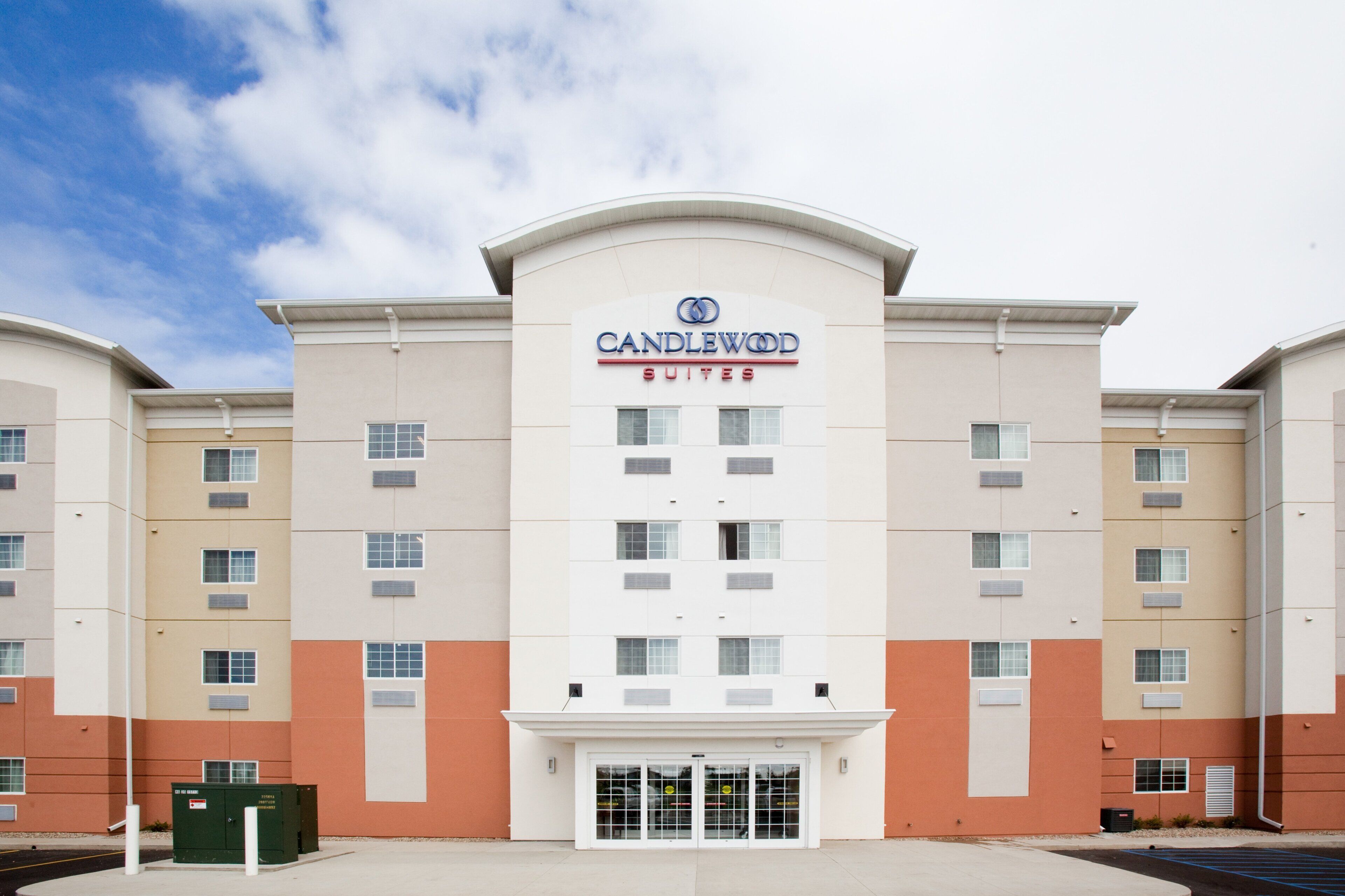 A hotel with a modern design, featuring a prominent 'Candlewood Suites' sign.