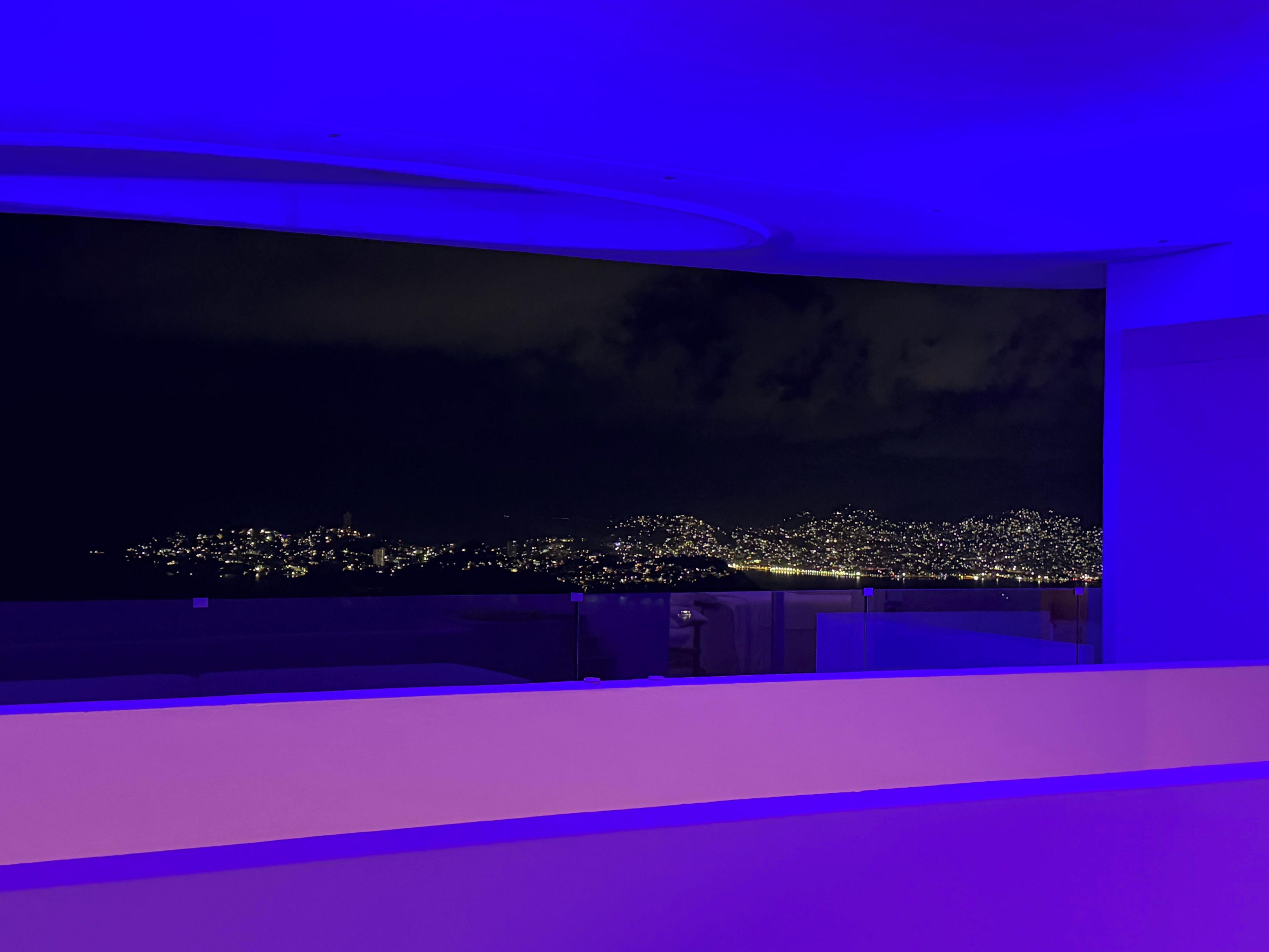 A room with a large curved screen displaying a cityscape at night.