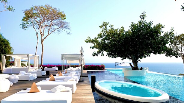 A luxurious poolside area with white lounge chairs and a hot tub, overlooking a clear blue sea. - Encanto Acapulco (Acapulco)