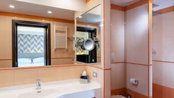 Ein modernes Badezimmer mit großem Spiegel, Waschbecken, Toilette und Dusche.