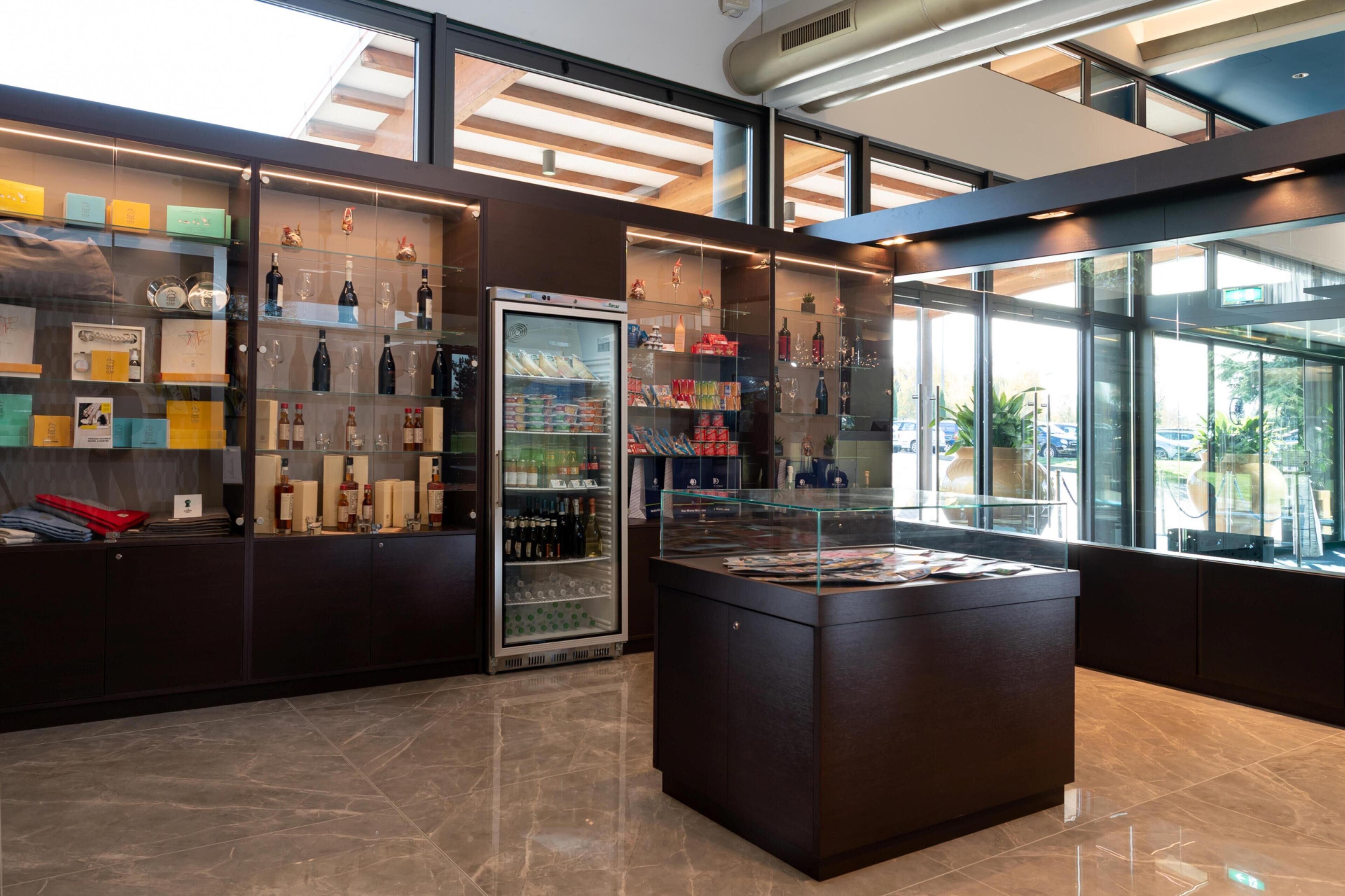 A modern hotel lobby with a glass display case, a refrigerated section, and a reception desk.