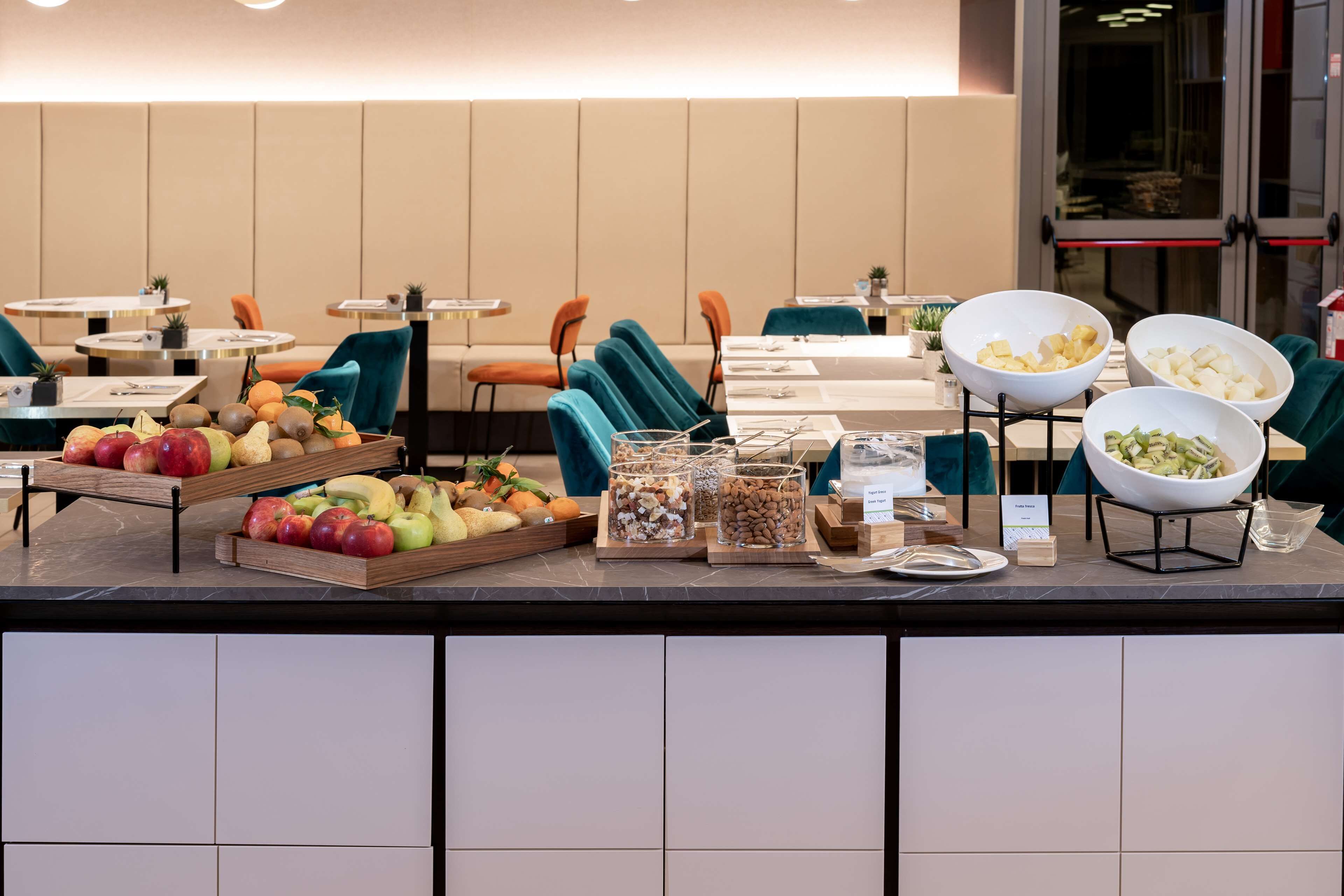 A buffet area with various fruits, nuts, and a salad bowl.