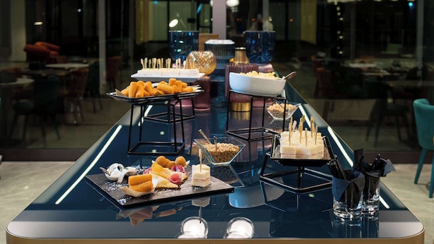 Una mesa de buffet con diversos alimentos y una vitrina de vidrio.
