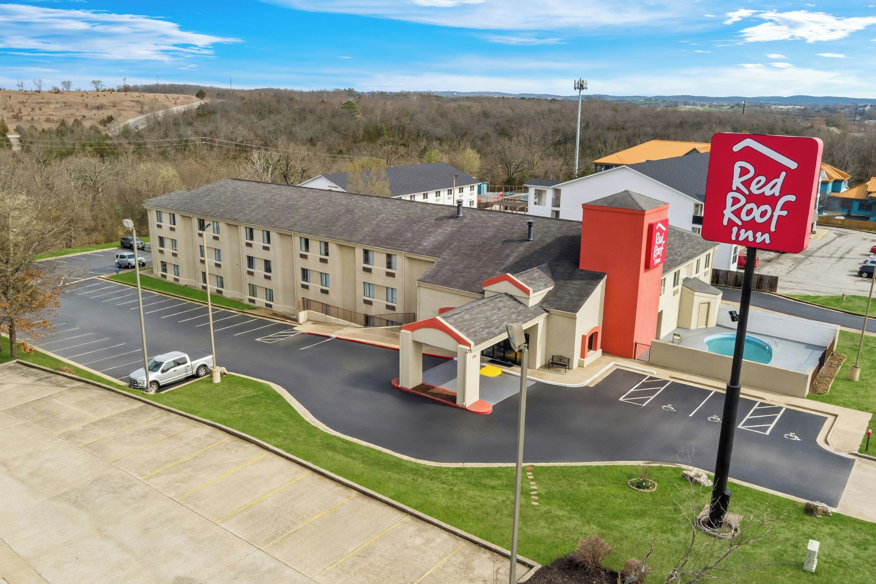 Un hôtel Red Roof Inn doté d’un parking, d’une piscine et d’un bâtiment aux couleurs rouge et blanche.