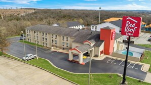 A Red Roof Inn with a parking lot, a swimming pool, and a building with a red and white color scheme. - Red Roof Inn Branson (Branson)
