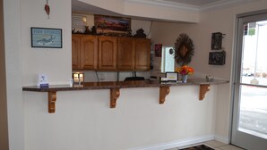 A kitchen with wooden cabinets, a countertop, and a rug. - National 9 - Nephi 9 Inn (Nephi)