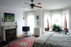 A bedroom with a bed, a fireplace, a television, and a ceiling fan. - Parkside Bed & Breakfast (Brooklyn)
