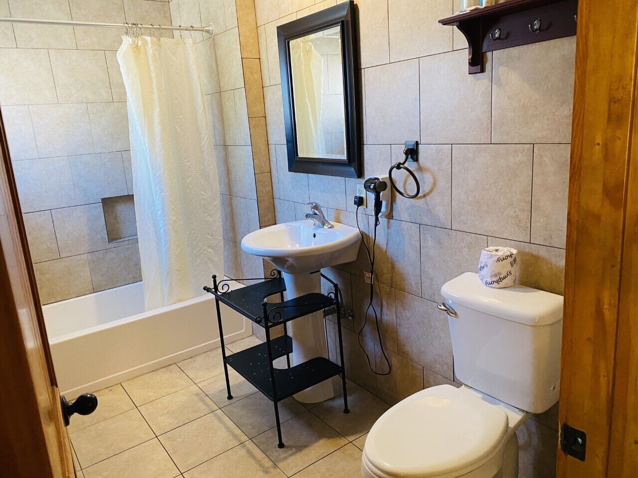 Un baño con bañera, lavabo, inodoro y espejo.