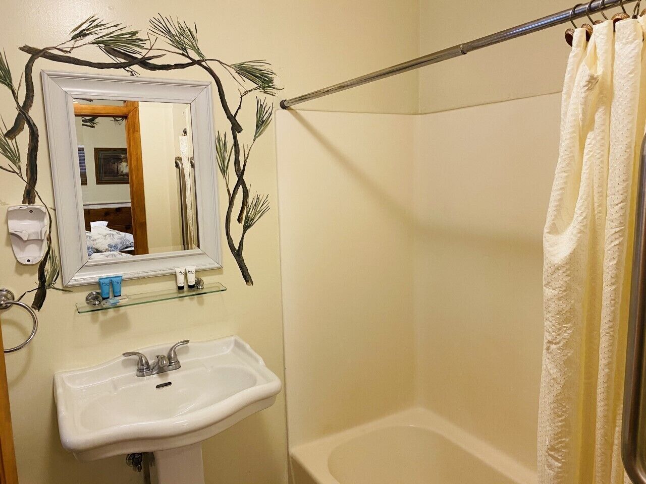 A bathroom with a white sink, a mirror, and a shower curtain.
