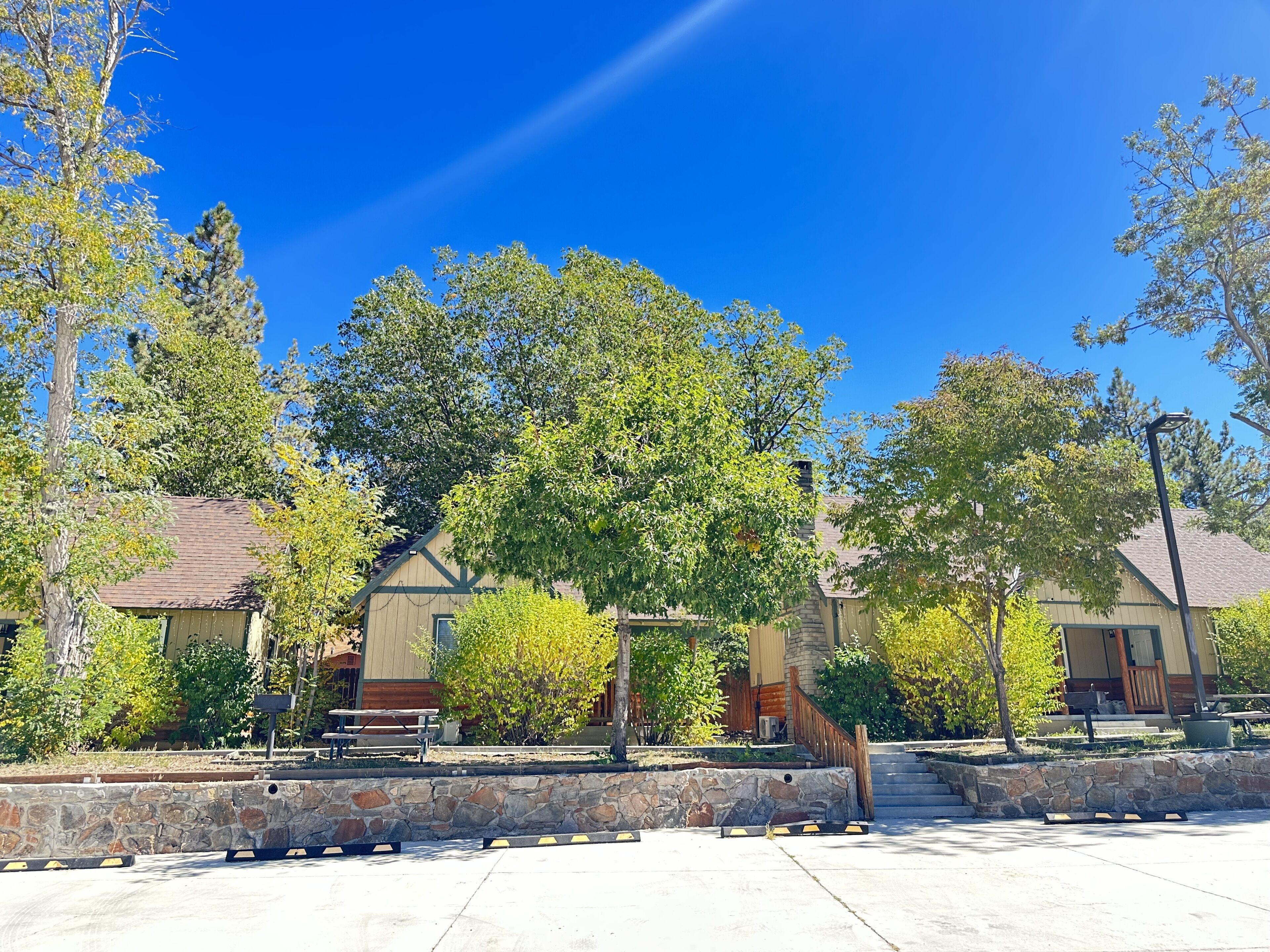 A building with a stone wall and a paved area with benches.