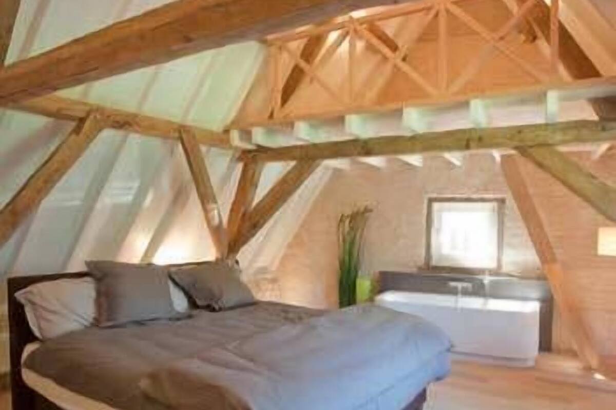 Una camera da letto con un letto, un comodino e una finestra.