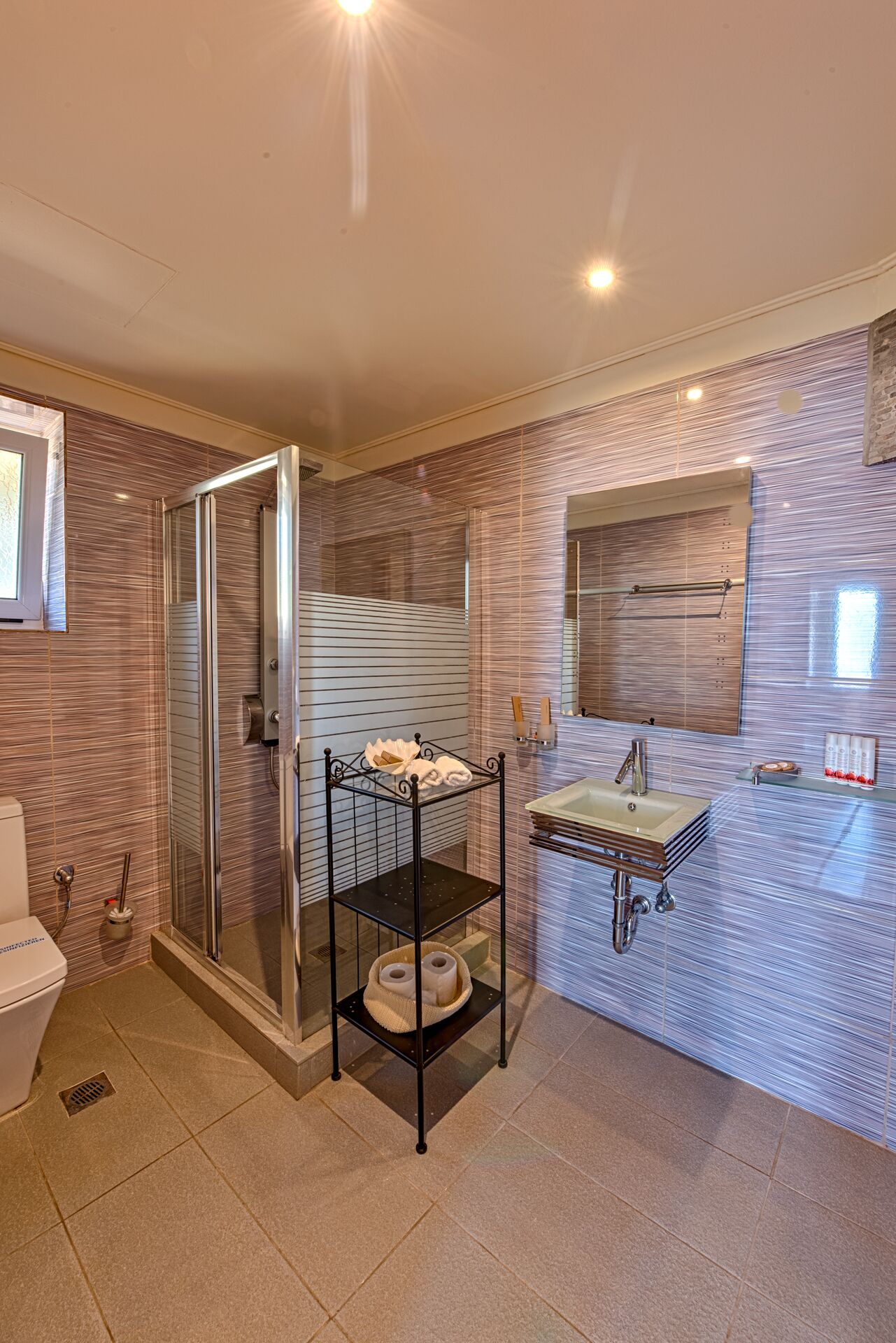 Un bagno moderno con doccia vetro, un mobile lavabo e un grande specchio.