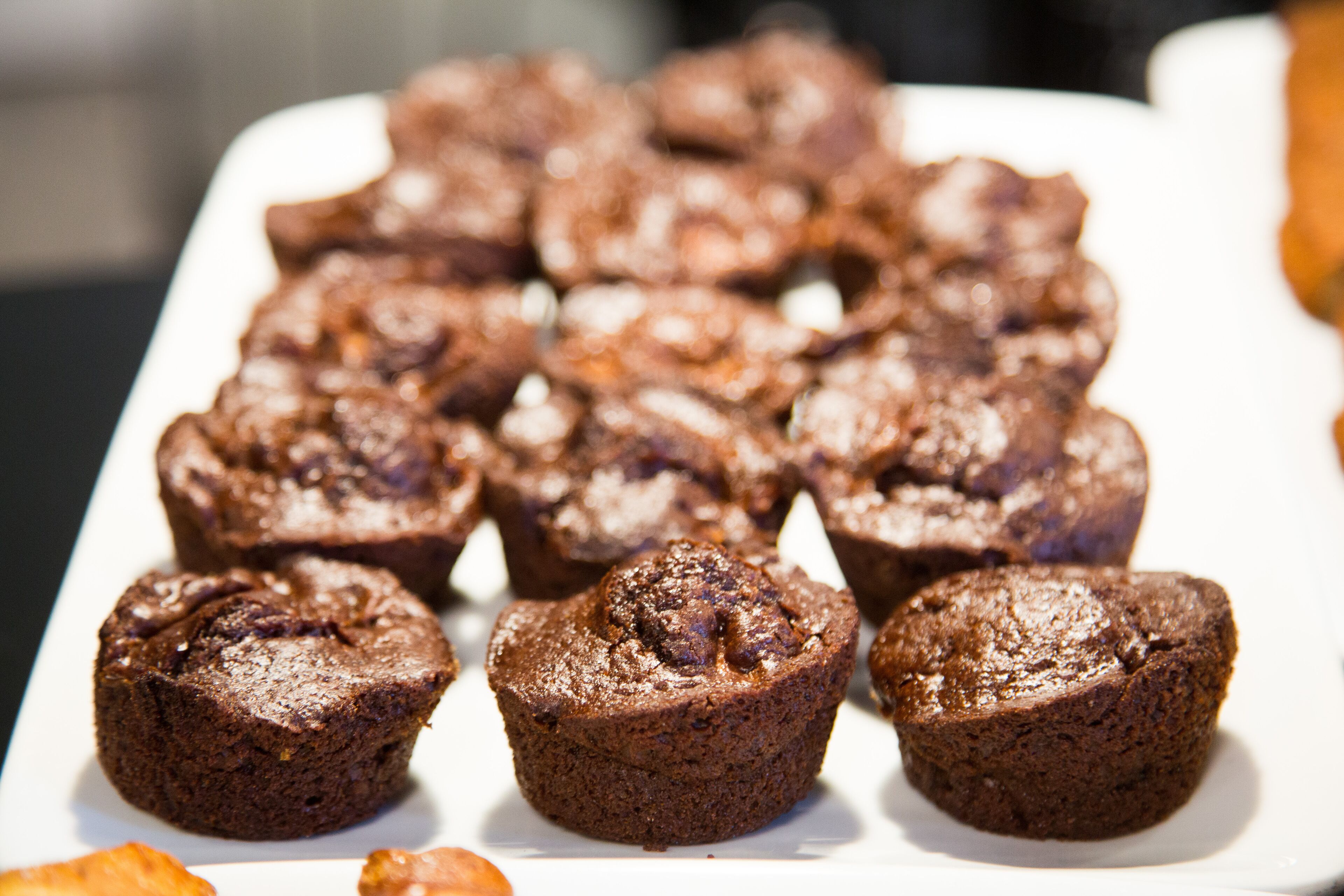 A tray of chocolate muffins on a white plate.