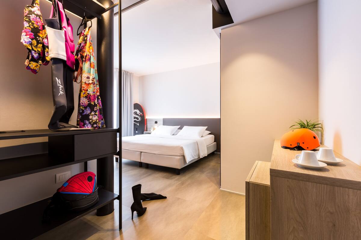 Hotellihuone, jossa on sänky, työpöytä ja vaatekaappi.