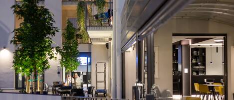 A modern indoor space with multiple levels, outdoor seating, and indoor dining areas.