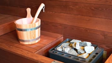 A wooden bench with a wooden bucket and a tray of stones.