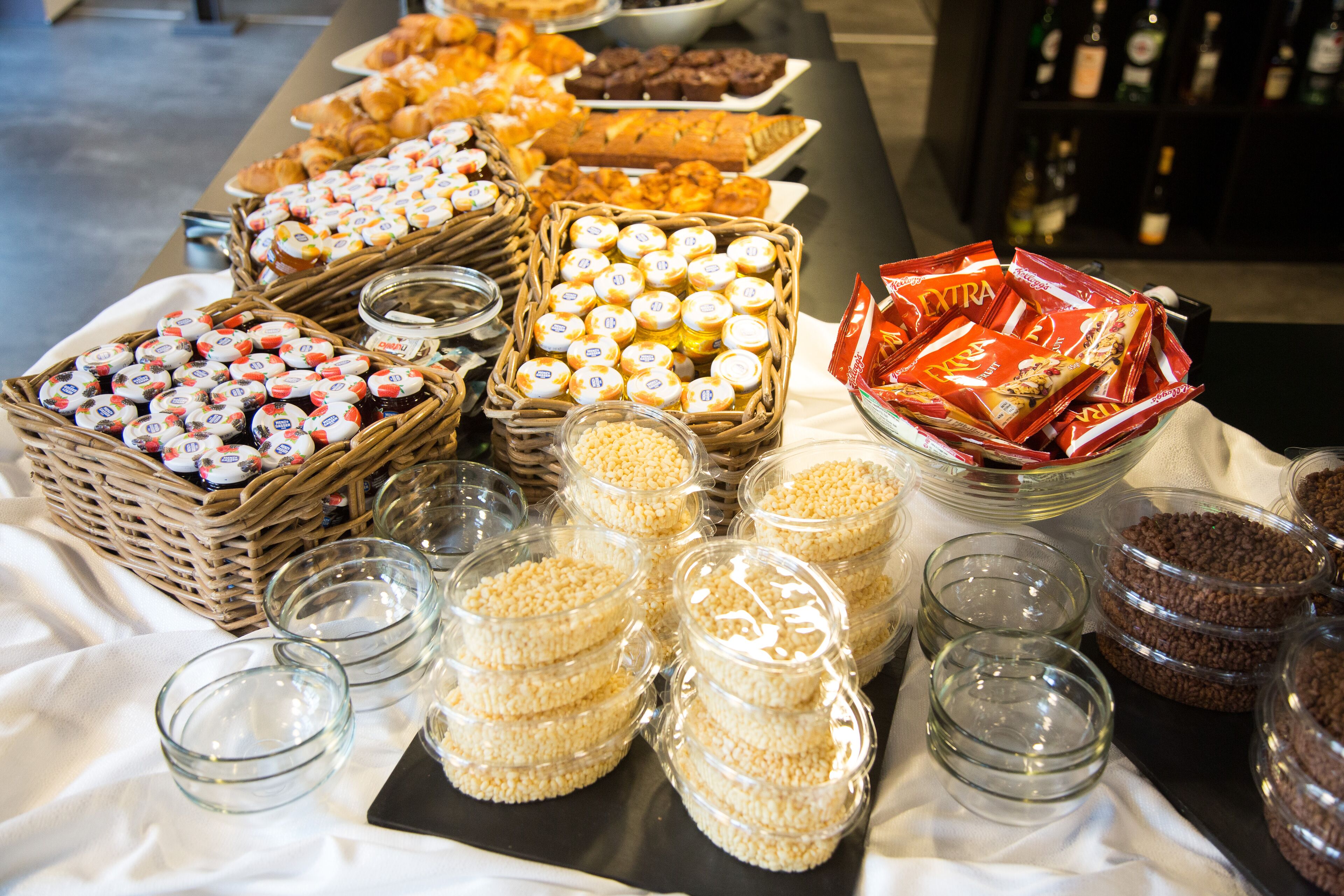 Ein Buffet mit verschiedenen Speisen, darunter Gebäck, Sandwiches und Beilagen.
