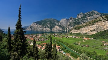 Un paysage montagneux avec un village, des vignobles en terrasses et un lac.