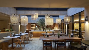 A modern restaurant with high ceilings, hanging woven light fixtures, wooden tables and chairs, and a herringbone floor pattern. - PortoBay Teatro (Porto)