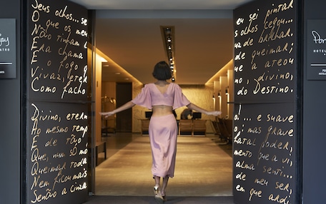 A person walking through a hallway with walls covered in handwritten text.