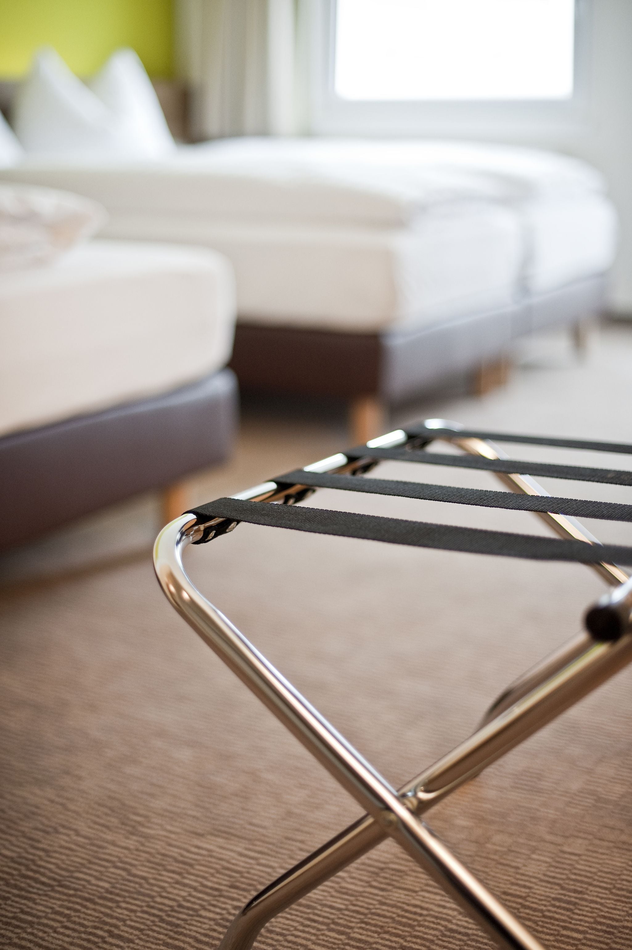 A close-up of a metal folding chair with a black seat and a metal frame.