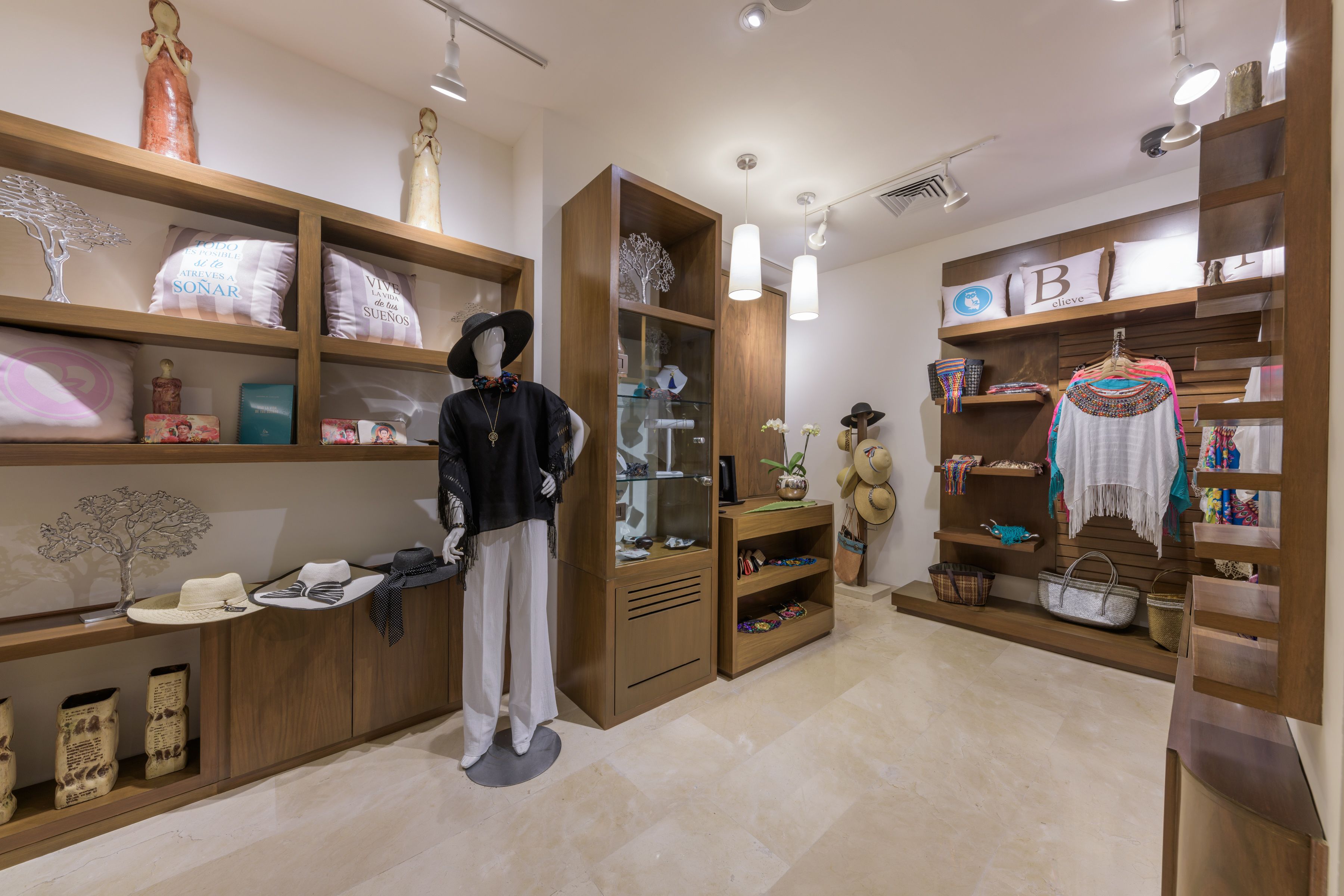 A boutique hotel interior with wooden shelving displaying hats, bags, and decorative items.