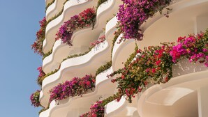 Un edificio con balcones curvos decorados con flores coloridas.
