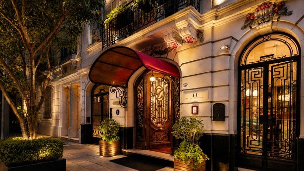 A hotel entrance with ornate doors, a red awning, and potted plants. - Duque Hotel Boutique & Spa (Buenos Aires)