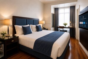 A hotel room with a large bed, bedside lamps, a TV, and a desk with a chair. - Duque Hotel Boutique & Spa (Buenos Aires)