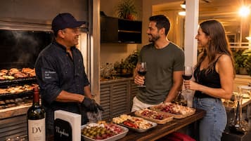 A bar area with a grill, wine bottles, and a variety of food items on a tray.