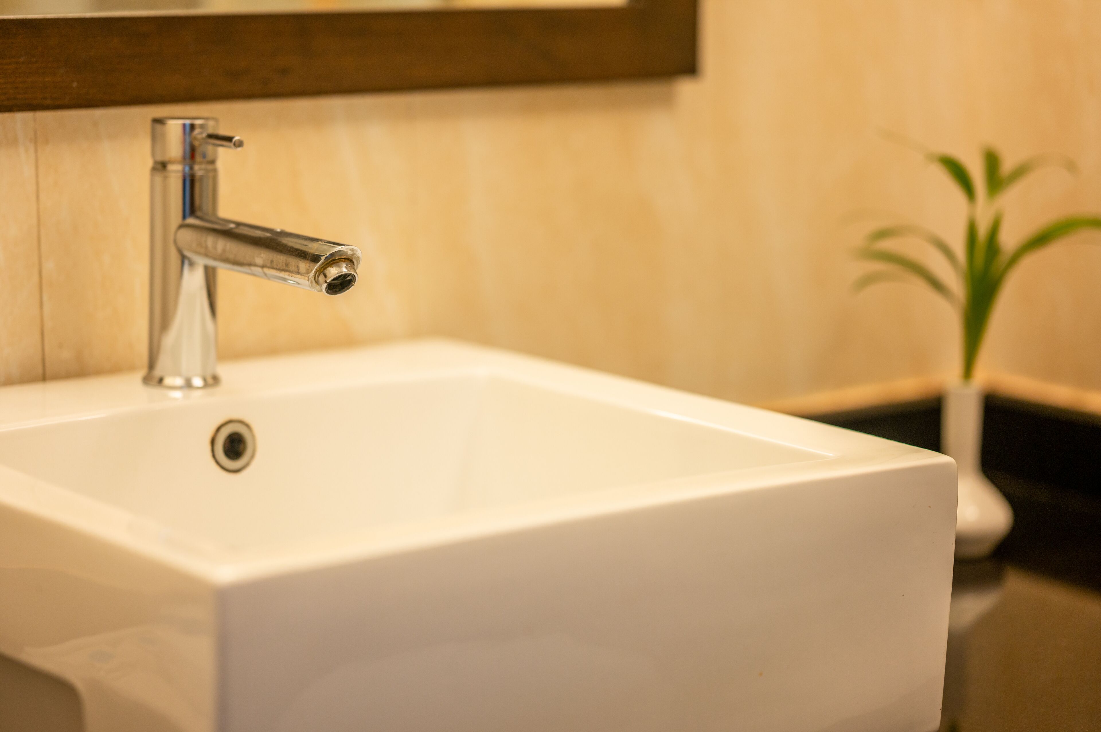 A white bathroom sink with a chrome faucet and a small drain hole.