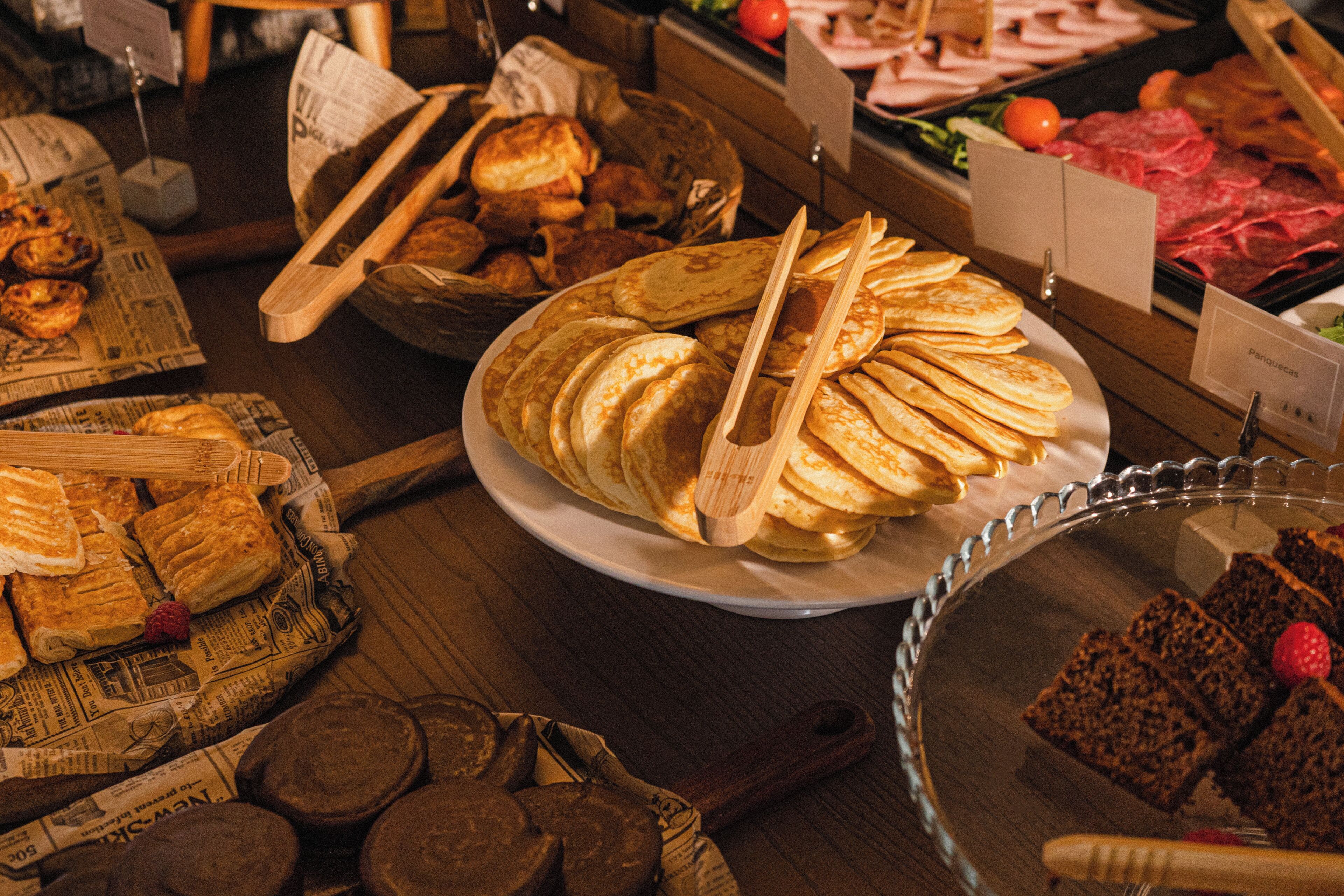 A buffet with various food items including bread, pastries, and desserts.