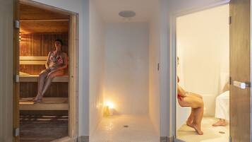 Relax in a spacious shower area with a tiled floor and walls, featuring a bench for unwinding.