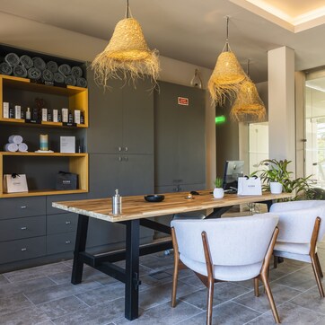 A modern kitchen with a wooden table, two chairs, and a built-in shelf with kitchen items.