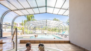 A hot tub area with a glass enclosure and a pool visible outside. - Vale da Lapa Village Resort (Lagoa)
