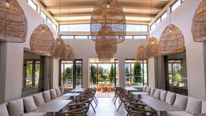 A spacious indoor area with high ceilings, large windows, and multiple seating arrangements including tables and sofas. - Vale da Lapa Village Resort (Lagoa)