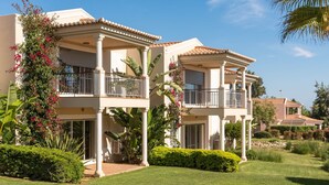 A two-story house with balconies, a well-maintained lawn, and tropical plants. - Vale da Lapa Village Resort (Lagoa)