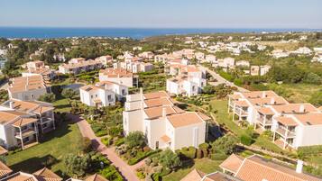 Un quartiere residenziale con edifici bianchi, tetti in tegole rosse e giardini curati.