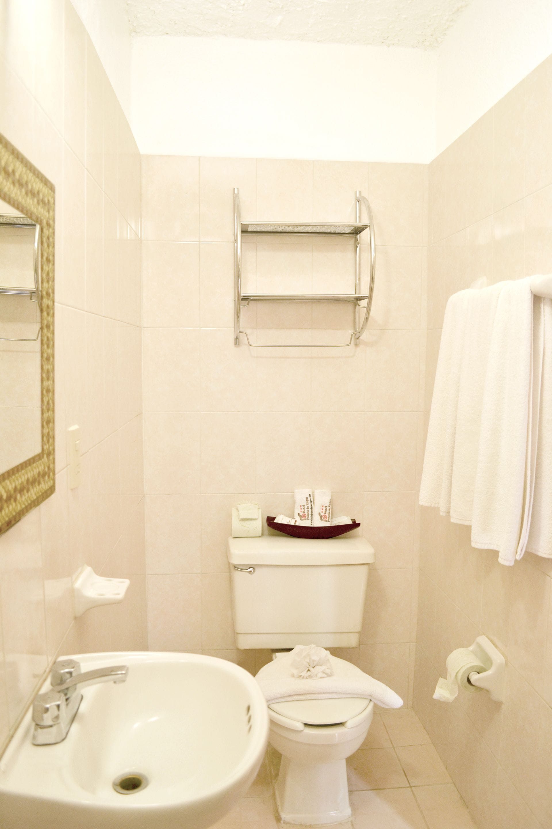 A bathroom with a sink, toilet, and towel rack.