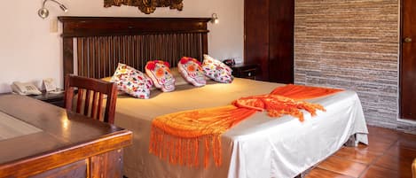 A hotel room with a wooden bed, a desk, and a chair.